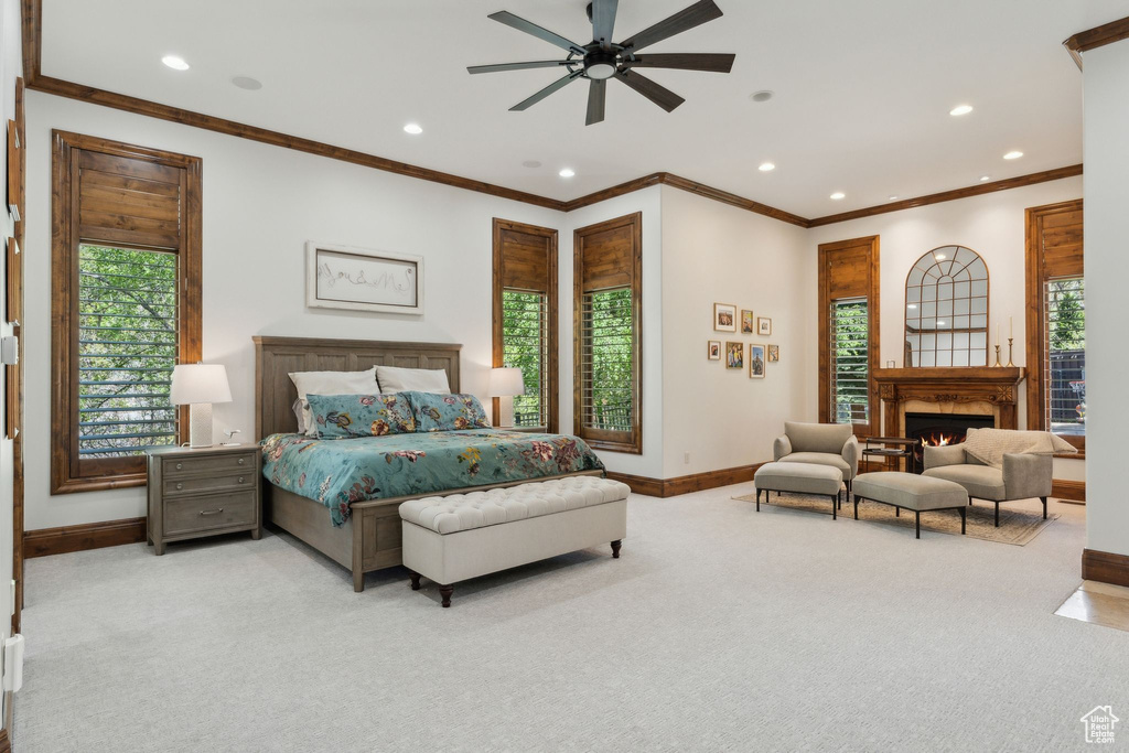 Bedroom with carpet, baseboards, recessed lighting, ornamental molding, and a warm lit fireplace