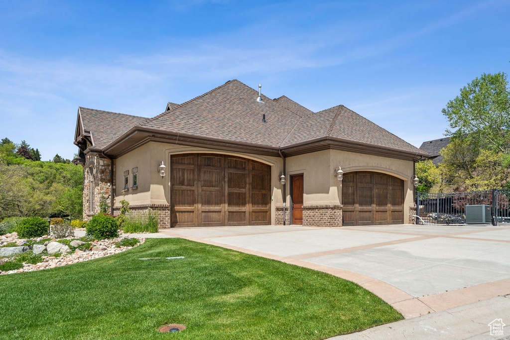 View of front facade with brick siding, an attached garage, and stucco siding