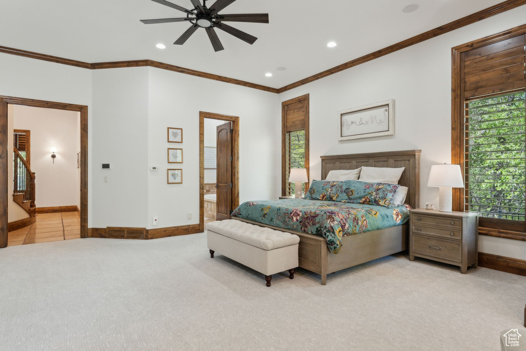 Bedroom featuring recessed lighting, crown molding, ensuite bath, light colored carpet, and baseboards