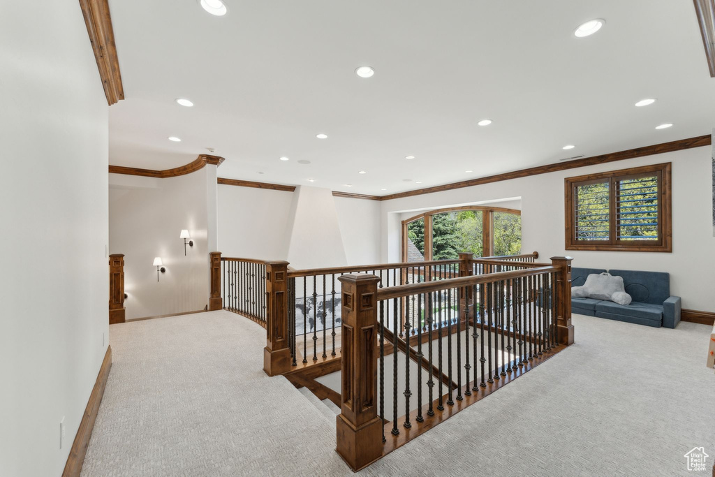 Hallway with an upstairs landing, carpet floors, crown molding, baseboards, and recessed lighting