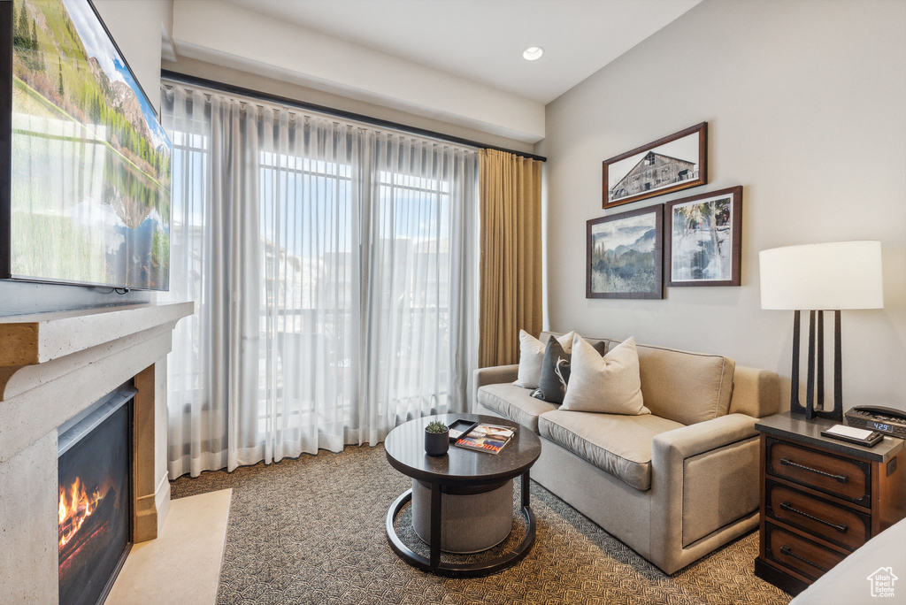 Carpeted living room featuring a premium fireplace and recessed lighting