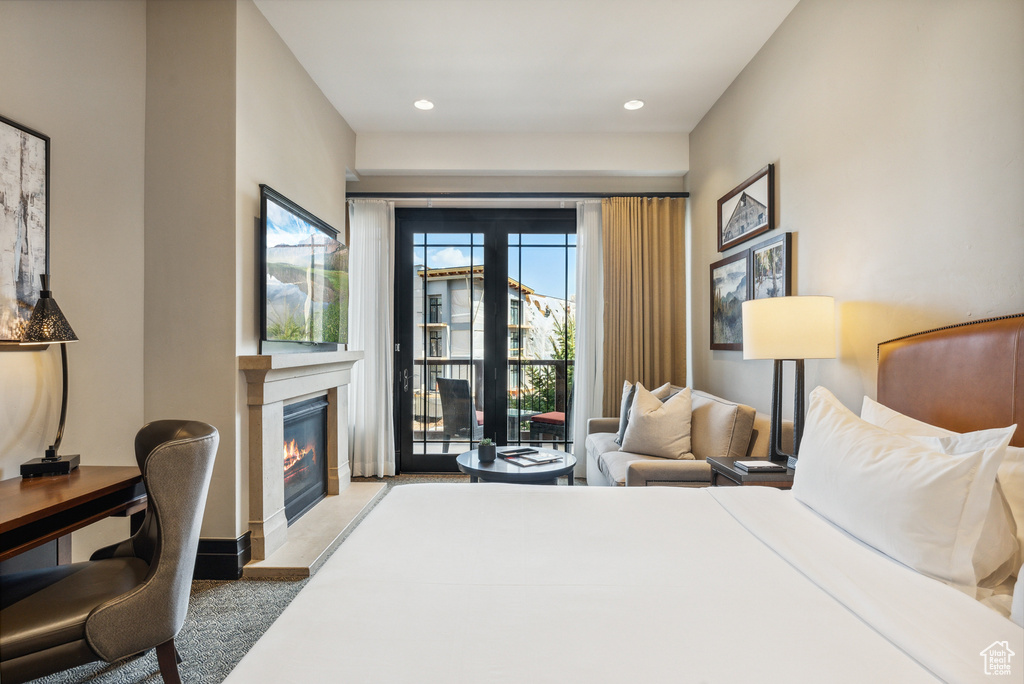 Bedroom featuring a glass covered fireplace, access to exterior, and recessed lighting