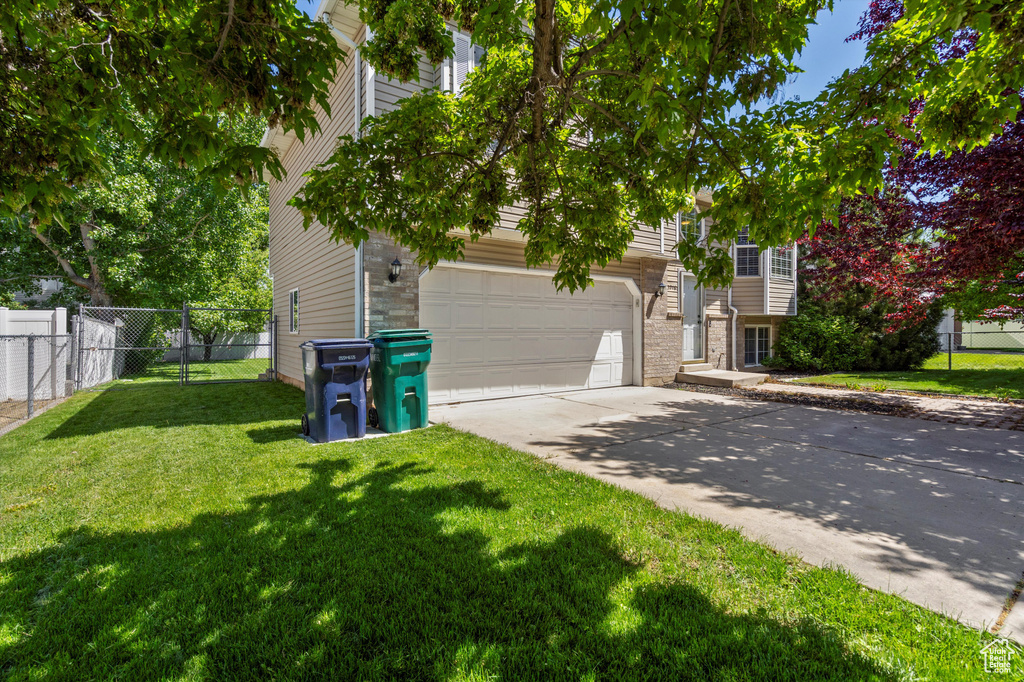 View of front of home featuring concrete driveway and an attached garage
