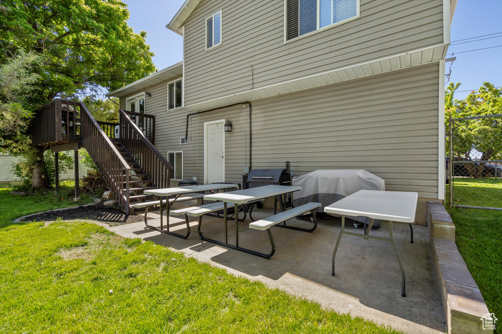 View of patio / terrace with stairway, a deck, and a grill