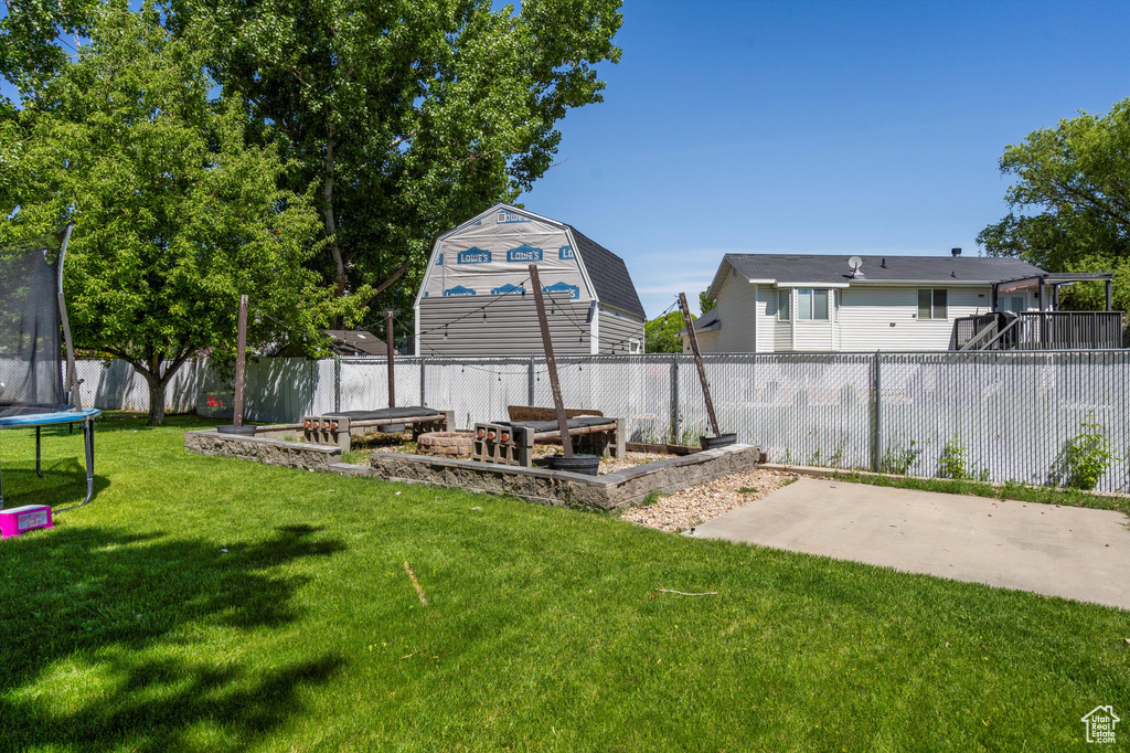View of yard with a trampoline and a patio