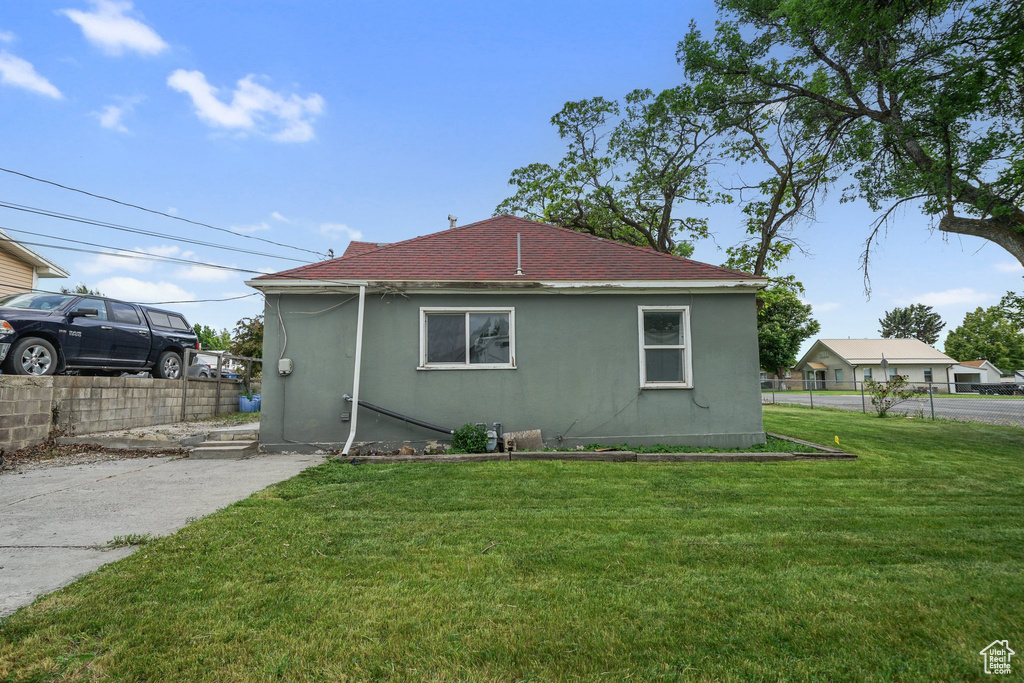 Back of property with stucco siding and a shingled roof