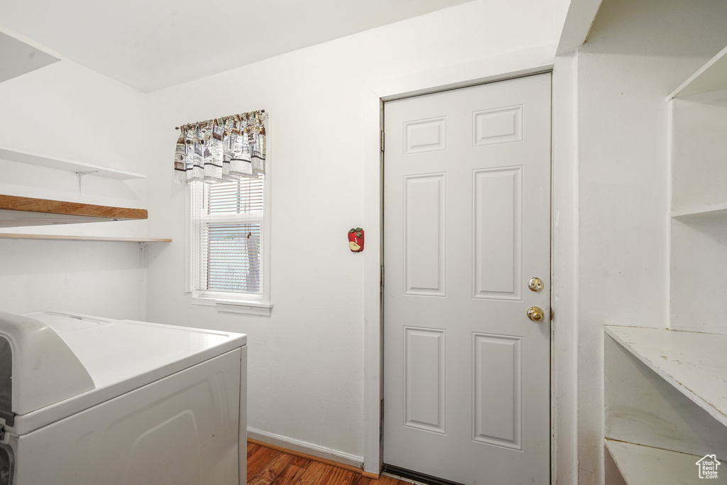 Laundry area with washer / dryer, wood finished floors, and baseboards
