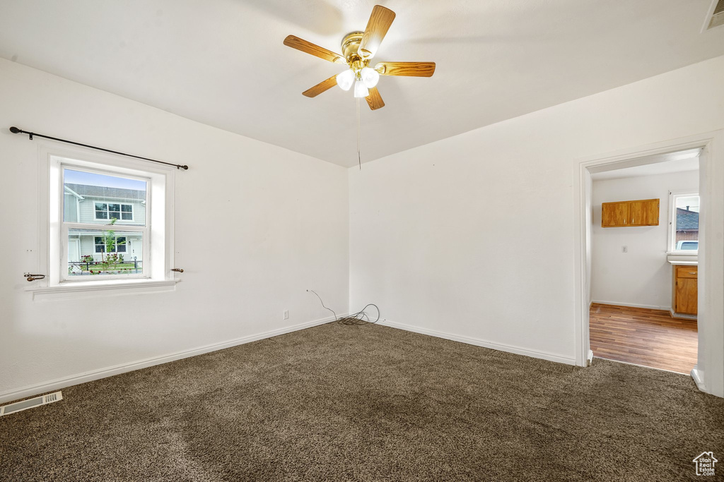 Unfurnished room featuring carpet floors, ceiling fan, and baseboards