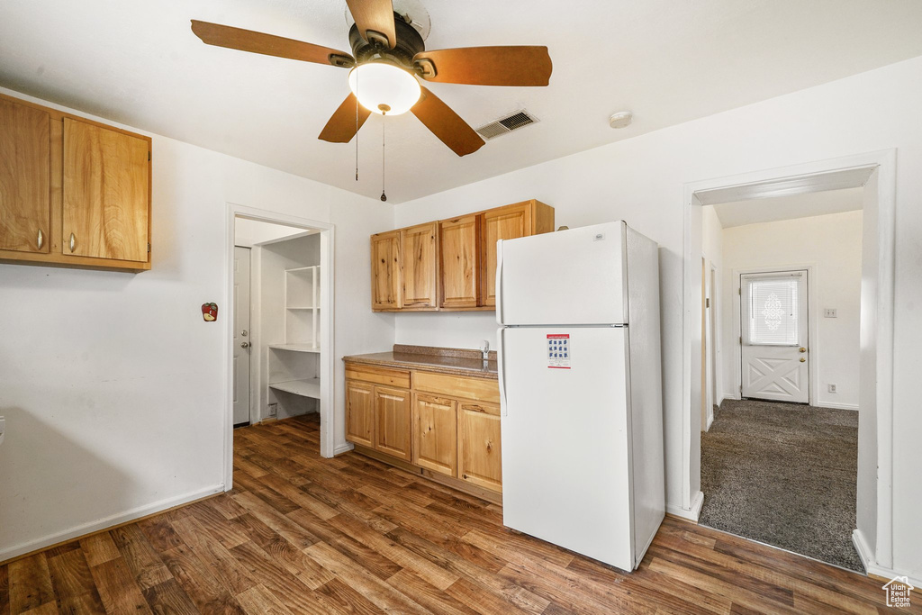 Kitchen featuring freestanding refrigerator, dark wood-type flooring, ceiling fan, and baseboards
