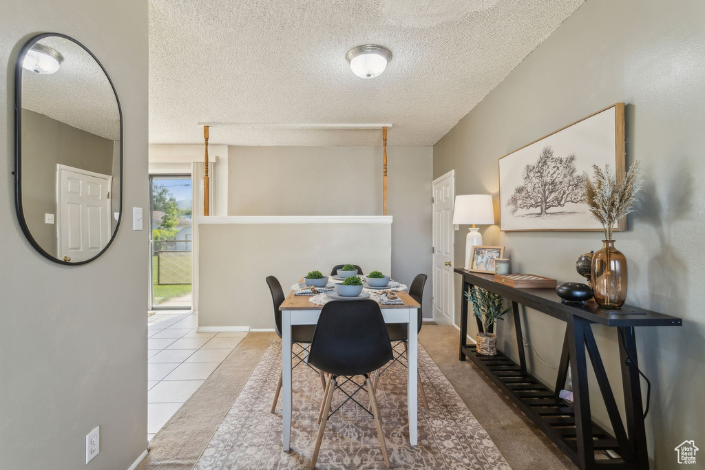 Dining room with a textured ceiling and tile patterned flooring