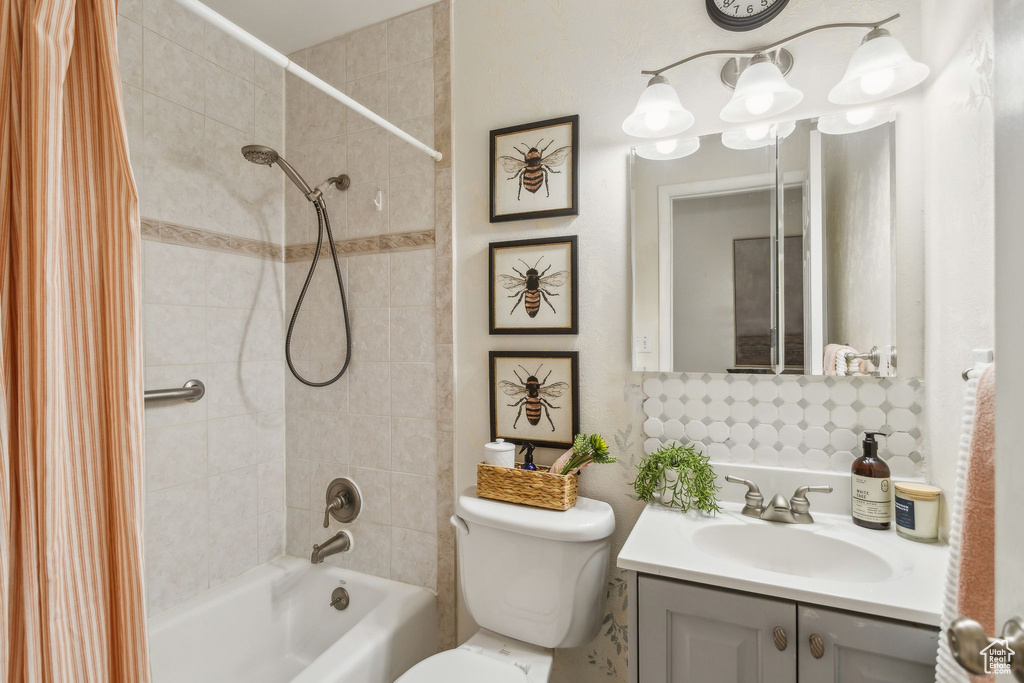 Bathroom featuring shower / tub combo, vanity, and toilet