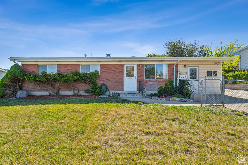 Single story home featuring entry steps, brick siding, and a gate