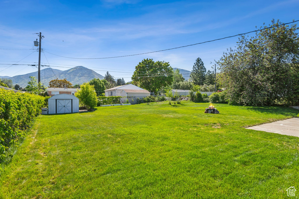 View of yard with a mountain view and an outdoor fire pit