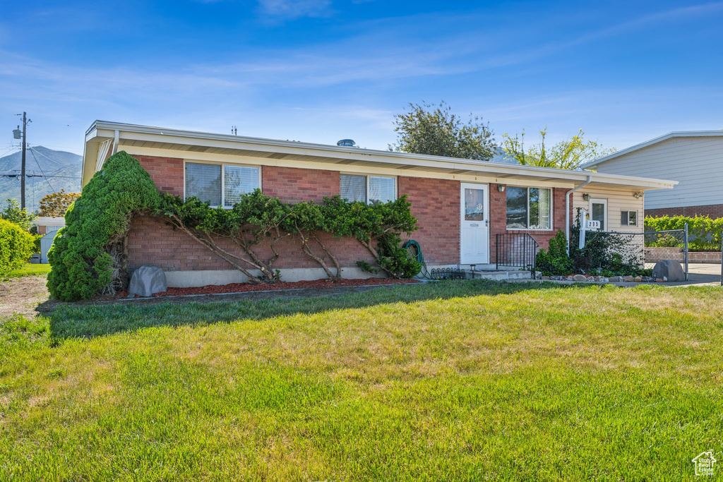 Ranch-style house with brick siding and a front yard