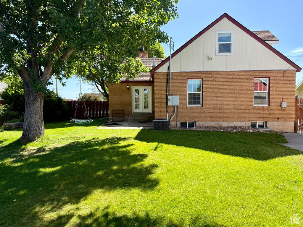 Back of house with brick siding, entry steps, french doors, and a shingled roof