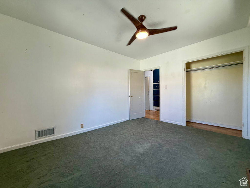 Unfurnished bedroom featuring carpet, baseboards, a closet, and a ceiling fan