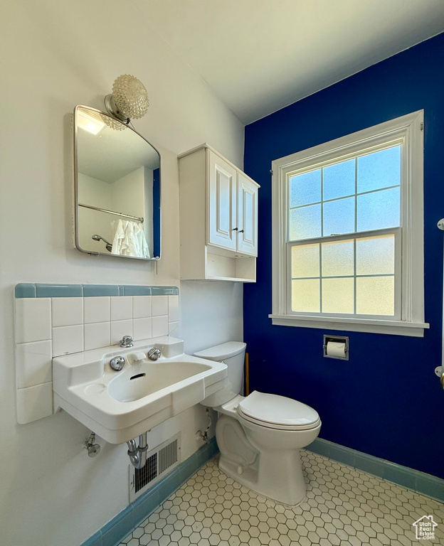 Full bath with toilet, baseboards, and a shower with shower curtain