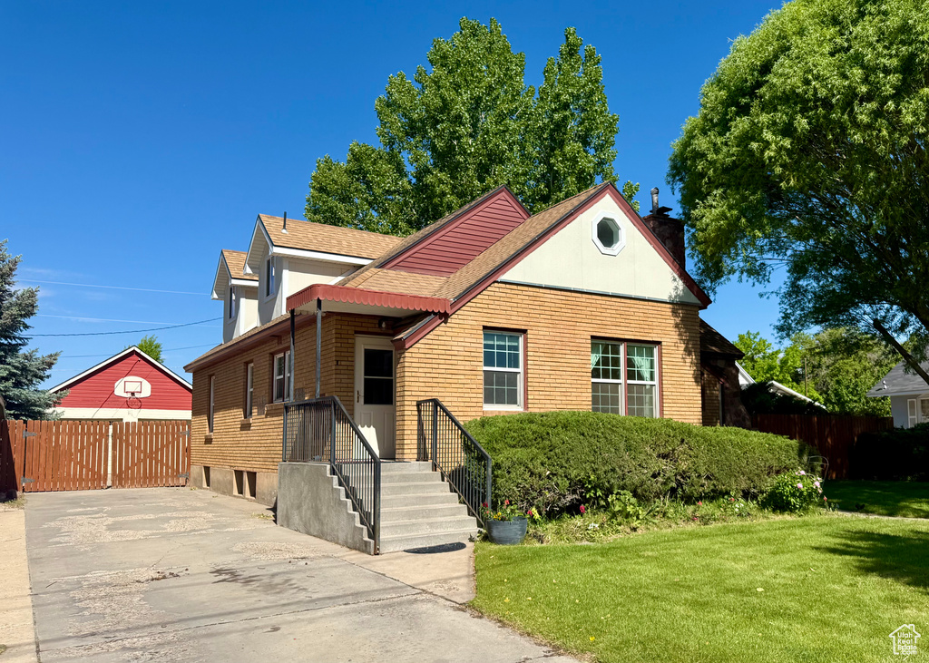 View of front facade with a chimney and roof with shingles