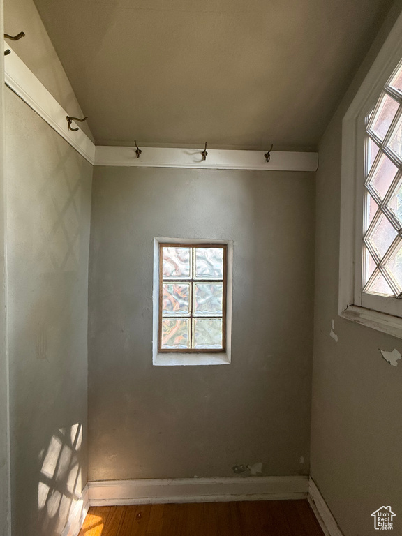 Spare room featuring wood finished floors, baseboards, and vaulted ceiling