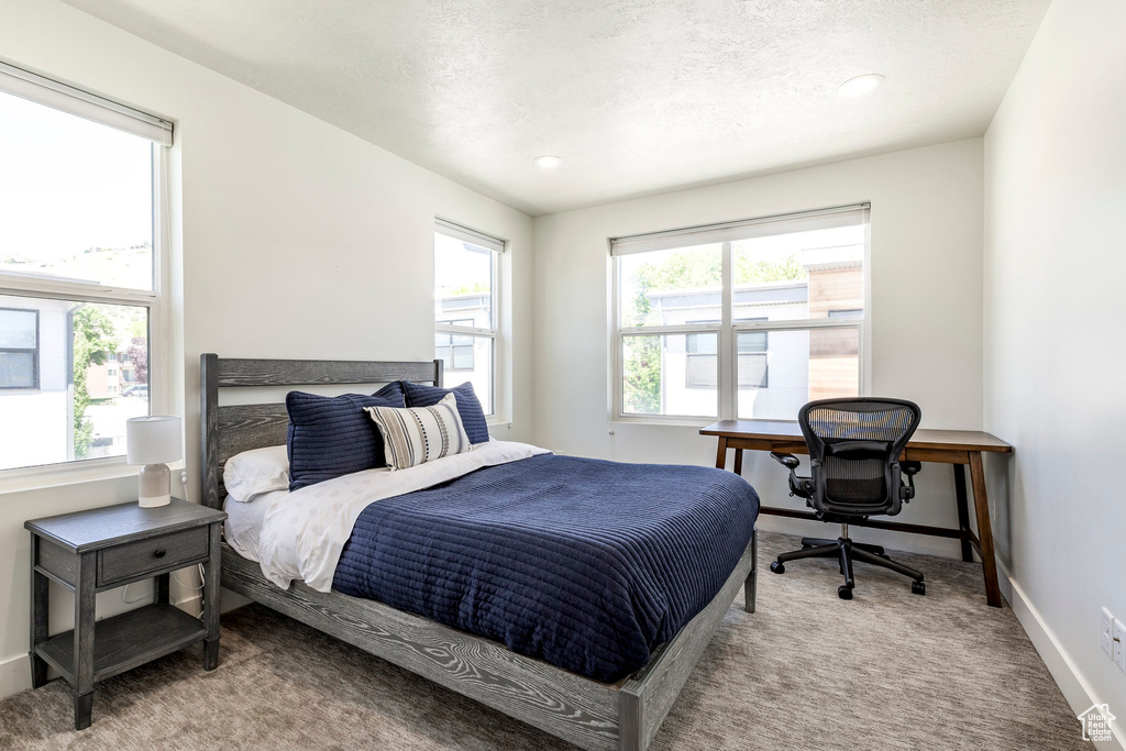 Carpeted bedroom with an office area, baseboards, recessed lighting, and a textured ceiling