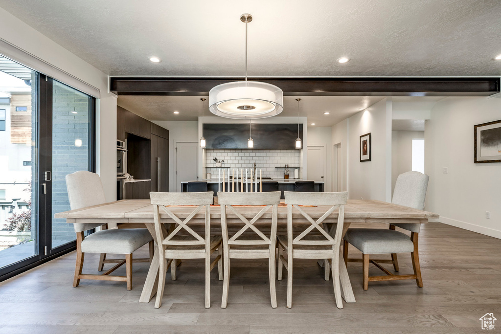 Dining area featuring light wood-style floors, baseboards, and recessed lighting