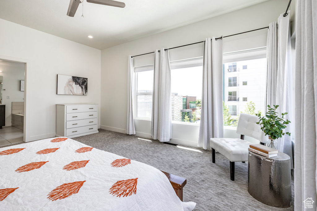 Bedroom featuring ensuite bathroom, baseboards, carpet floors, and ceiling fan