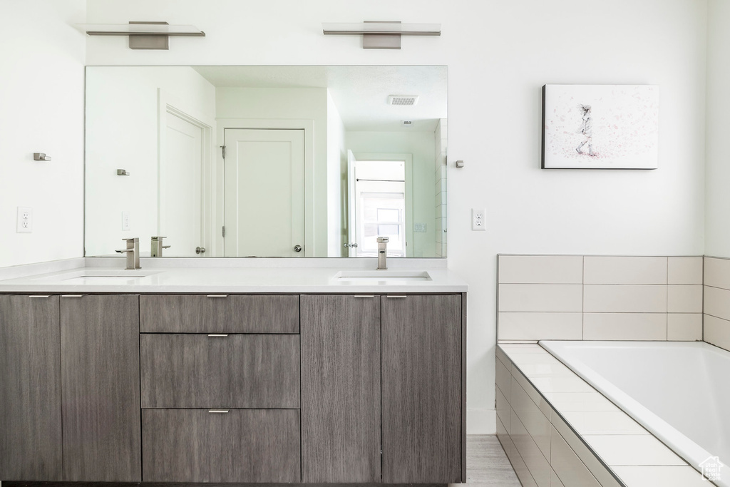 Full bathroom featuring double vanity and a bath