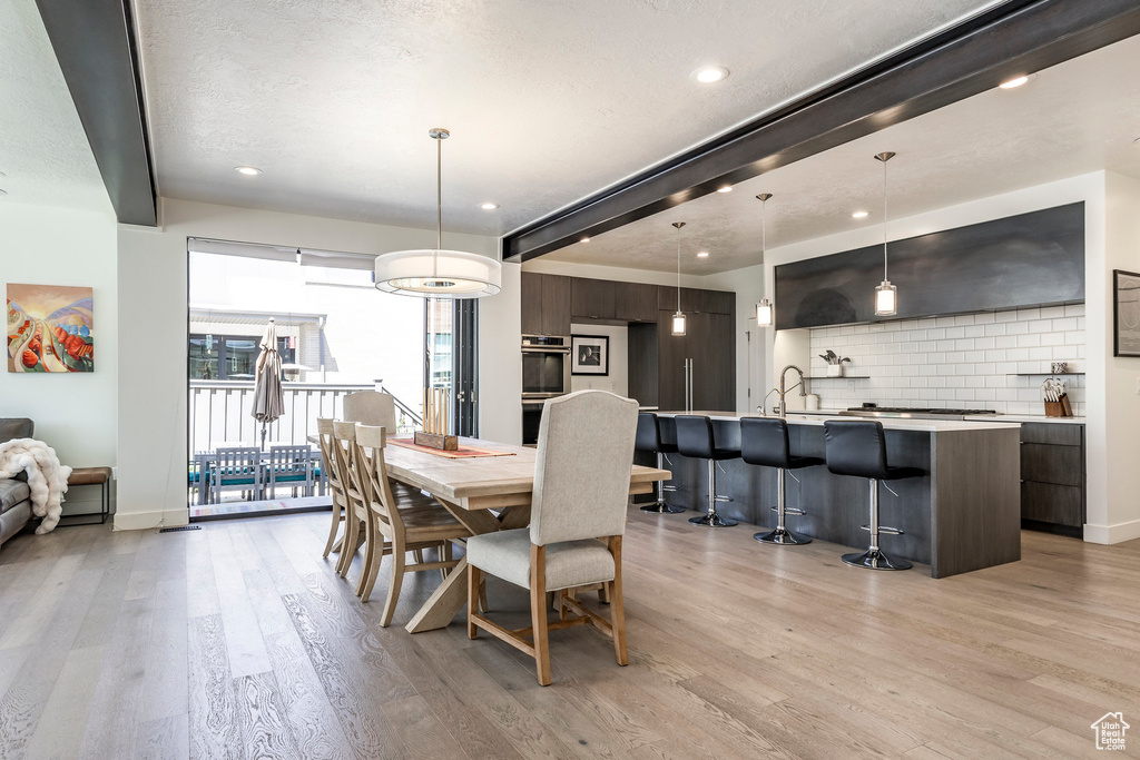 Dining room with light wood finished floors, recessed lighting, and baseboards