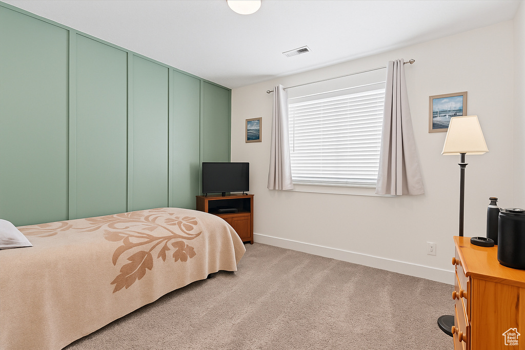 Bedroom featuring baseboards, light colored carpet, and a closet