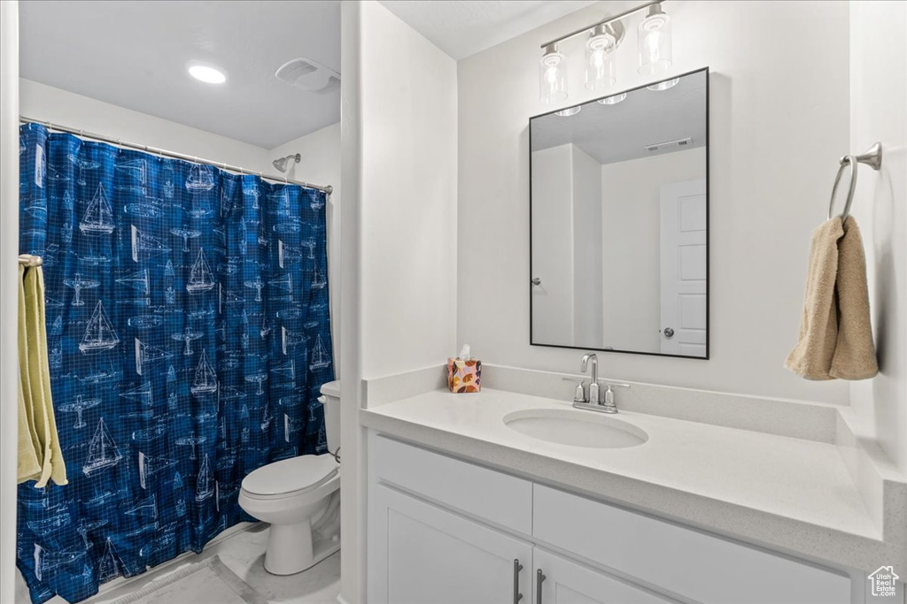 Bathroom featuring toilet, vanity, a shower with curtain, and marble finish flooring