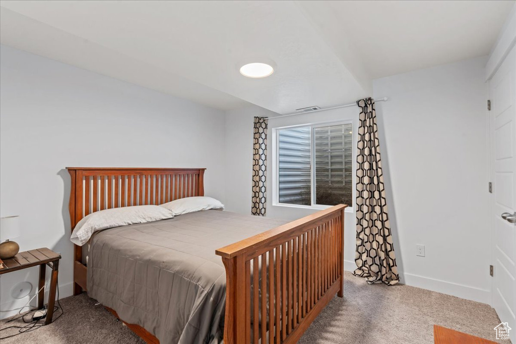 Bedroom featuring carpet and baseboards