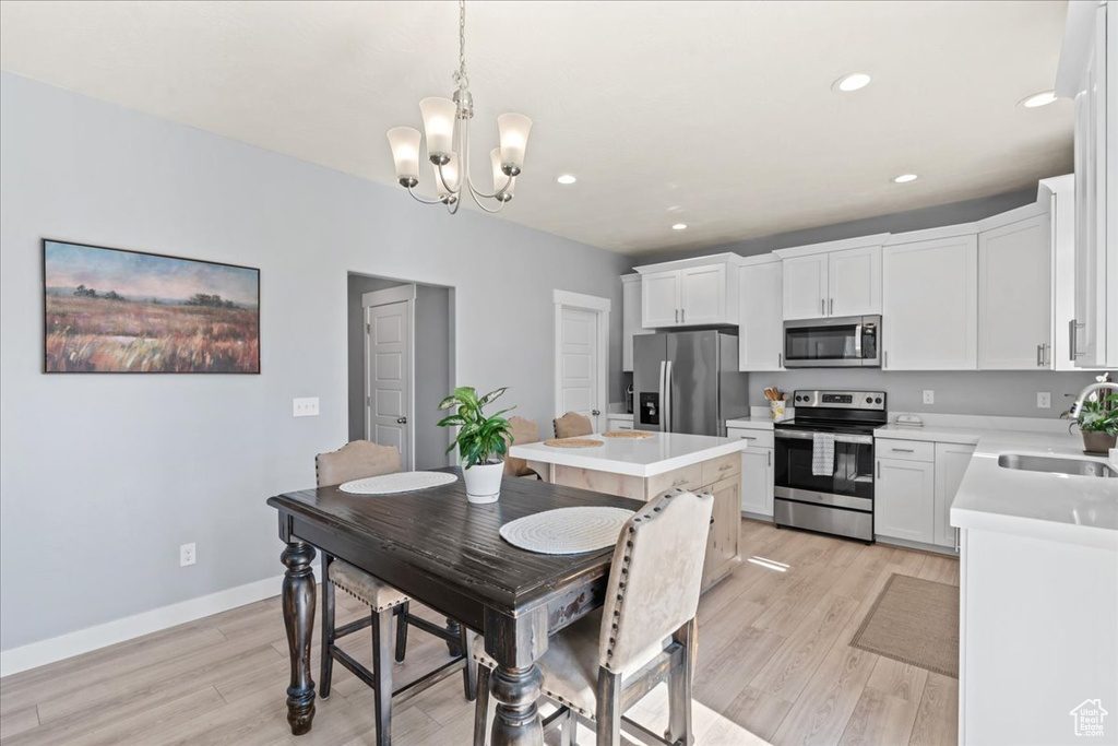 Dining space featuring light wood-style floors, a chandelier, recessed lighting, and baseboards
