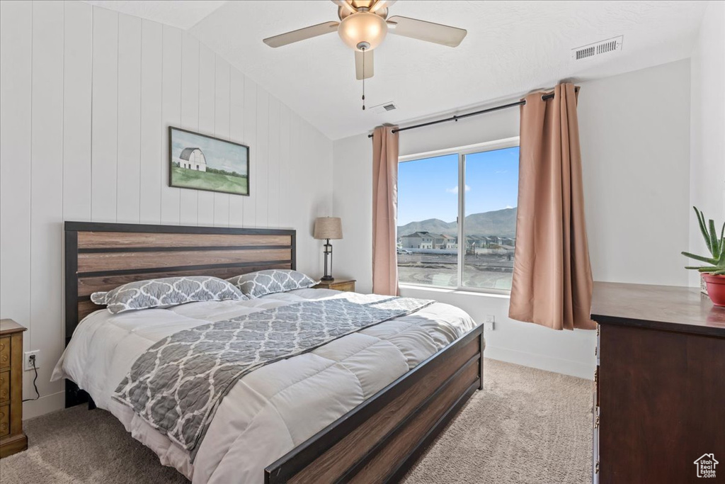 Bedroom featuring vaulted ceiling, carpet flooring, a mountain view, and ceiling fan