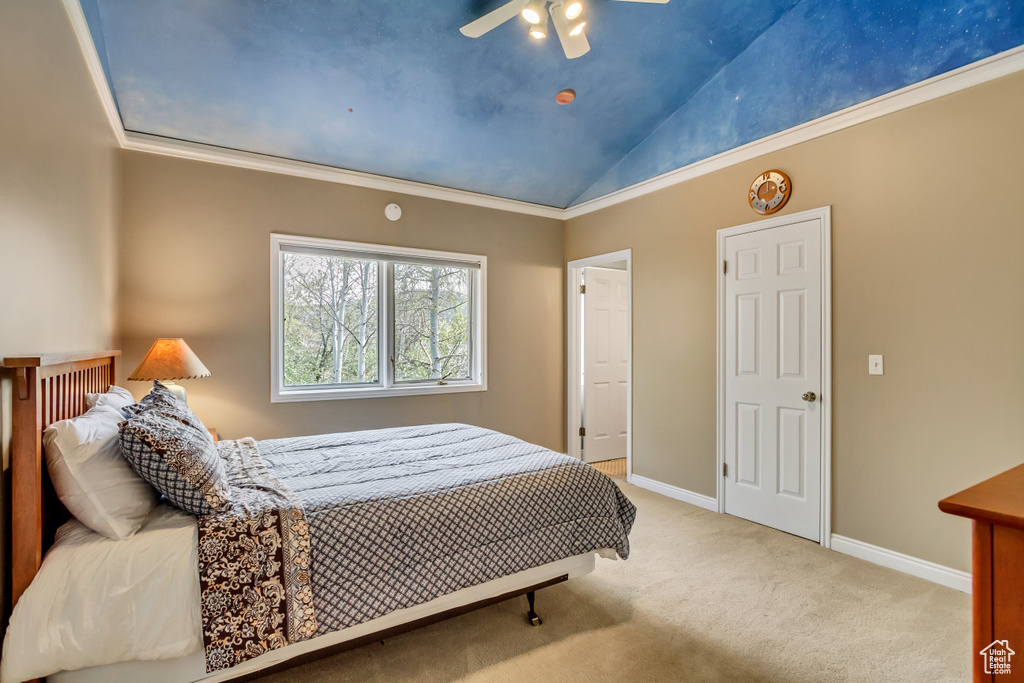 Carpeted bedroom with baseboards, vaulted ceiling, a ceiling fan, and crown molding