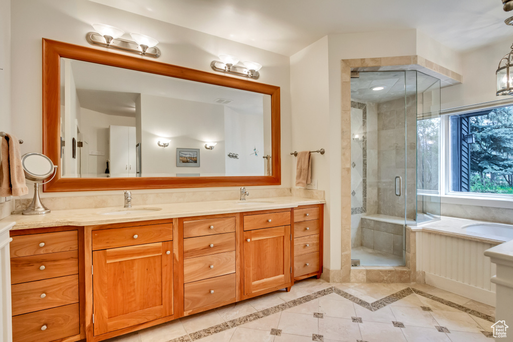 Bathroom featuring double vanity, a stall shower, a bath, and tile patterned flooring