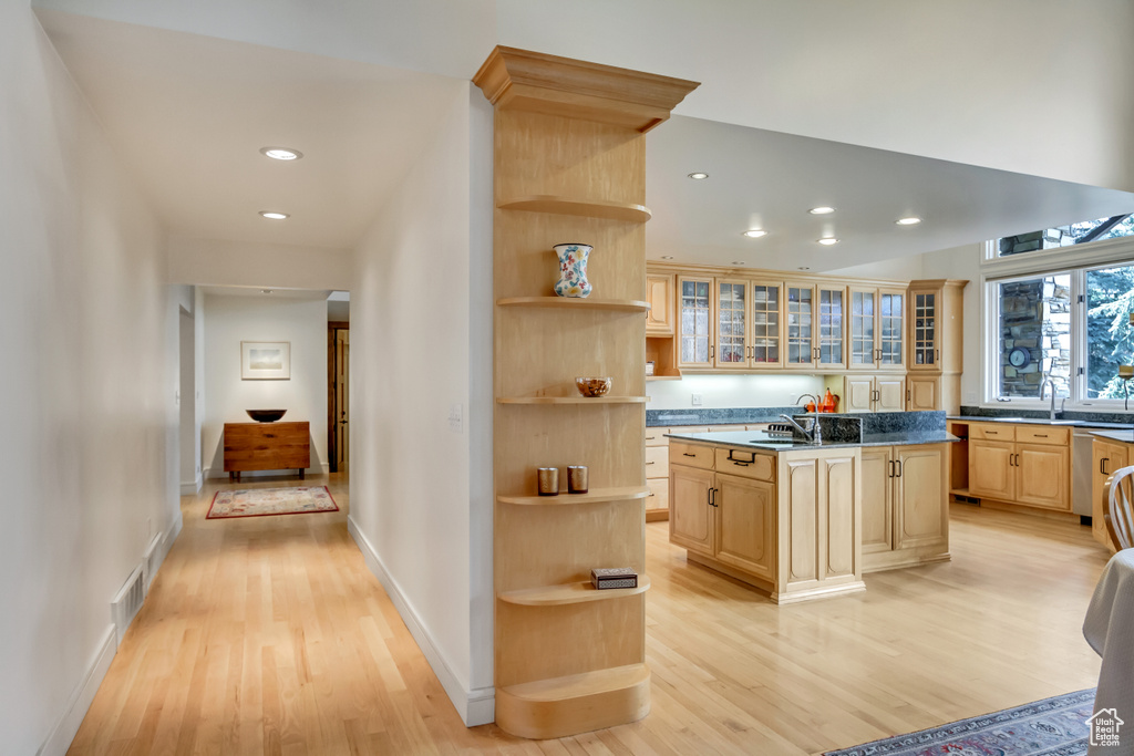 Kitchen featuring open shelves, light brown cabinets, light wood finished floors, a center island with sink, and recessed lighting