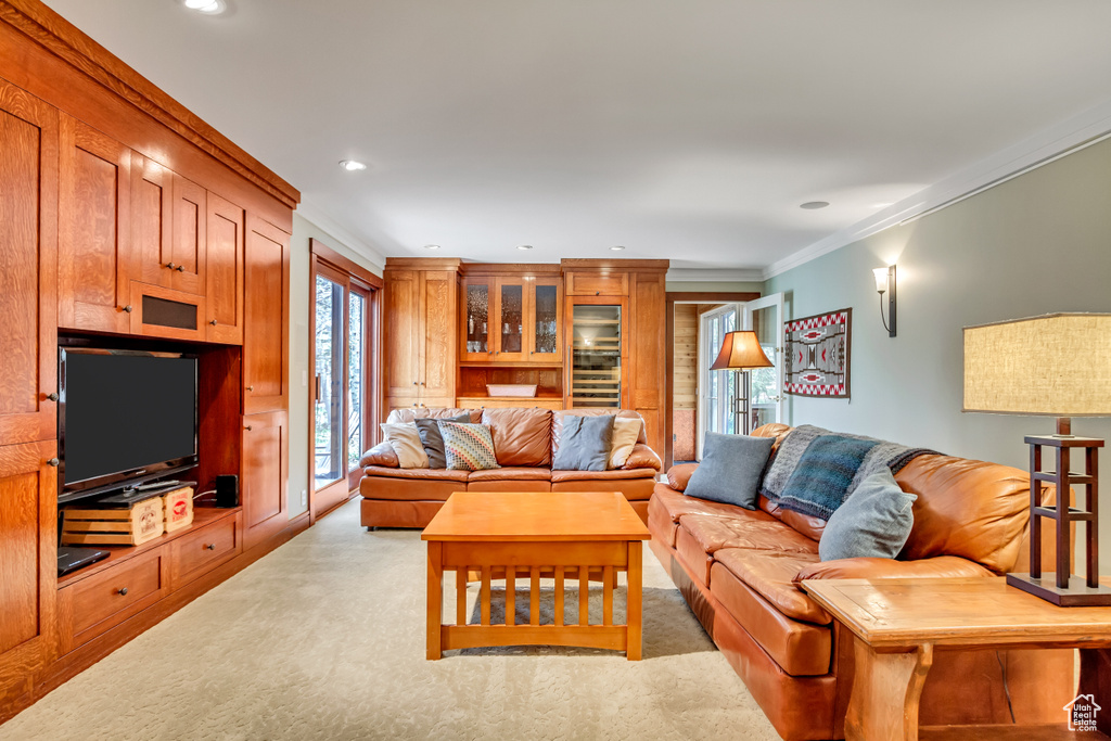 Living area featuring light carpet, ornamental molding, and recessed lighting