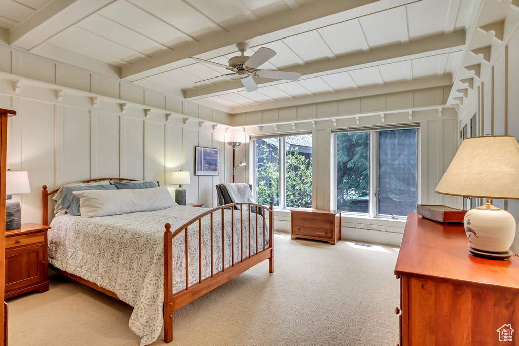 Carpeted bedroom with beamed ceiling and ceiling fan
