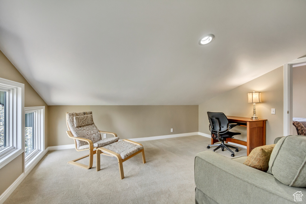 Office with vaulted ceiling, light carpet, and baseboards
