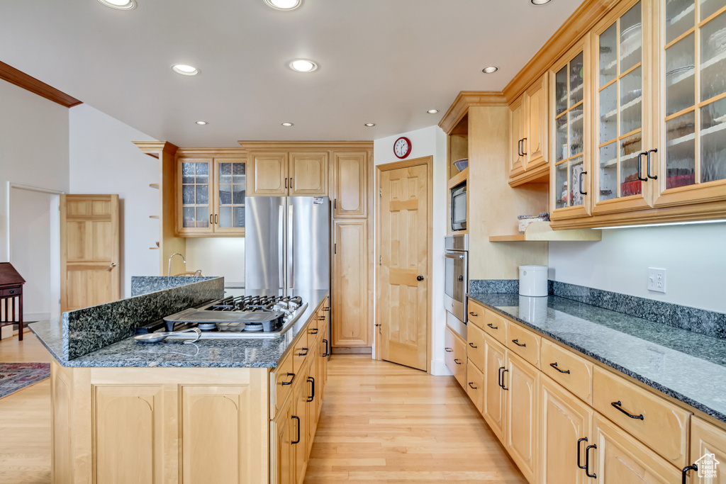 Kitchen featuring light brown cabinetry, light wood-style floors, stainless steel appliances, a center island, and recessed lighting