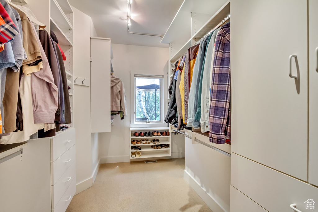 Walk in closet with light carpet