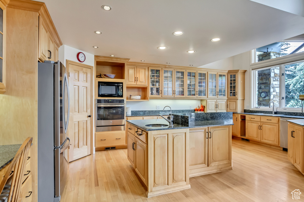 Kitchen with appliances with stainless steel finishes, a kitchen island with sink, light brown cabinetry, light wood-style floors, and recessed lighting