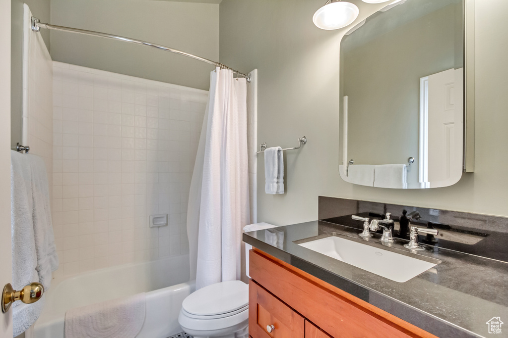 Full bath featuring vanity, shower / bathtub combination with curtain, and toilet