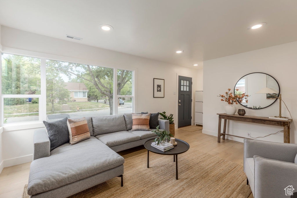 Living area featuring light wood-style floors, baseboards, and recessed lighting