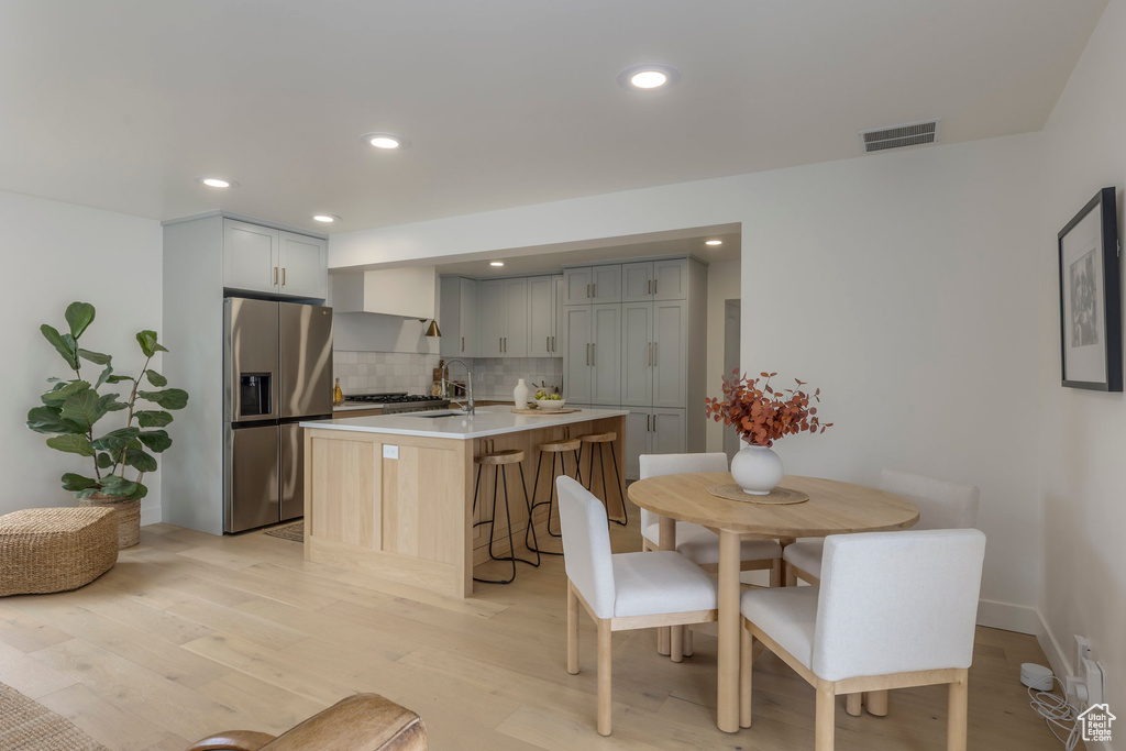 Dining area featuring light wood finished floors and recessed lighting