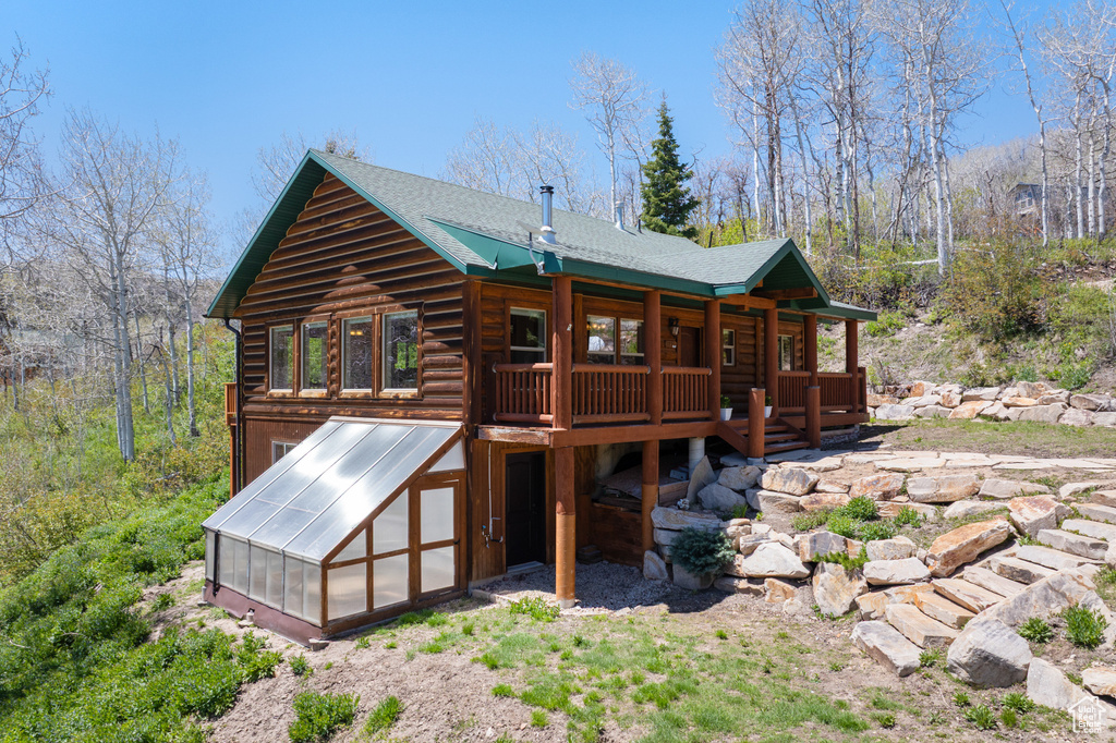 Rear view of house featuring an exterior structure and a deck