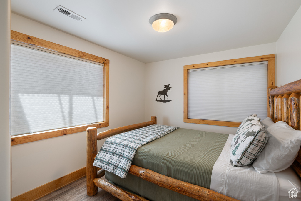 Bedroom with wood finished floors and baseboards
