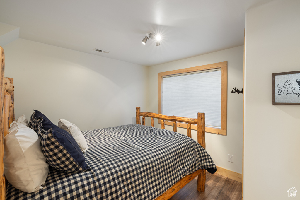 Bedroom with wood finished floors and baseboards