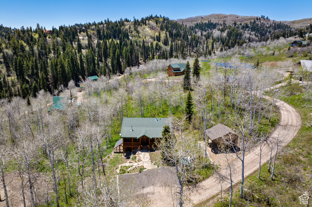 View of subject property featuring a forest and a mountainous background