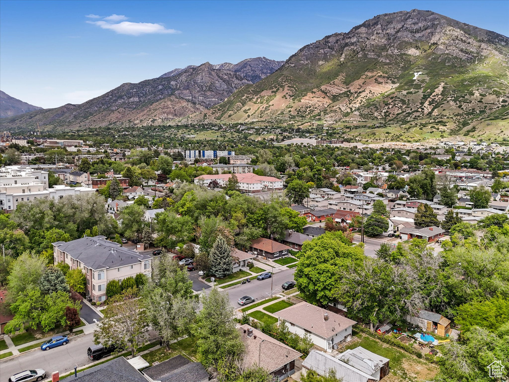 Aerial view of property and surrounding area featuring a mountain backdrop and nearby suburban area